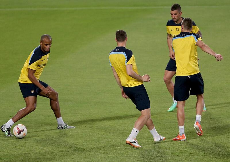 Manchester City defender Vincent Kompany, left, and Aleksandar Kolarov, far right, in action with teammates during a team training session in Abu Dhabi on Wednesday. Satish Kumar / The National / May 14, 2014