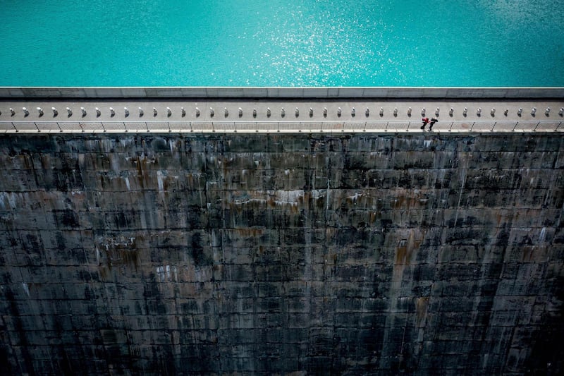 Milk cans are lined up on the top of the Cleuson dam during a land art installation by photographer Gerard Benoit a la Guillaume above Haute-Nendaz, Switzerland.  AFP