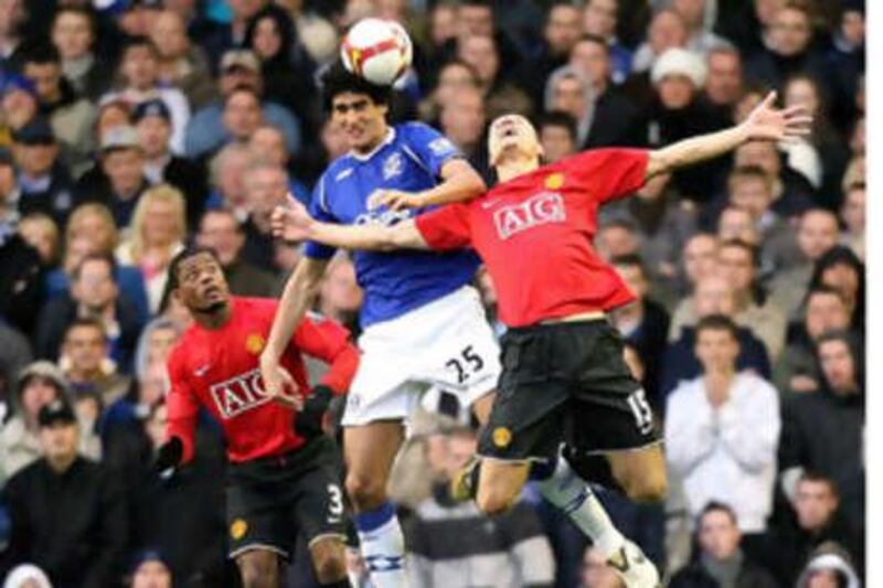 Everton's Marouane Fellaini, center, and Manchester United's Nemanja Vidic, right, battle for the ball during the English Premier League soccer match at Goodison Park, Liverpool, England, Saturday Oct. 25, 2008. (AP Photo/PA, Martin Rickett) ** UNITED KINGDOM OUT NO SALES NO ARCHIVE - NO INTERNET/MOBILE USAGE WITHOUT FAPL LICENCE - SEE IPTC SPECIAL INSTRUCTIONS FIELD FOR DETAILS **  *** Local Caption ***  TH801_Britain_Soccer.jpg