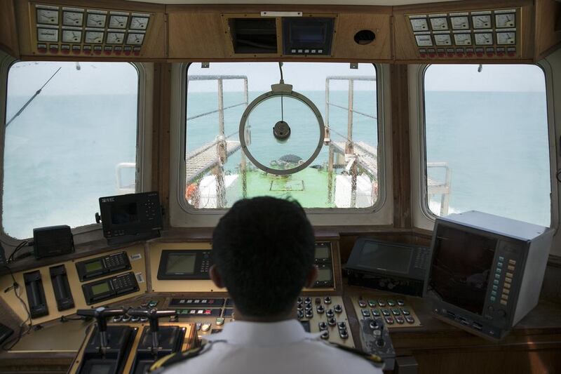 Captain Abdullah al Hamadi stirs his pilot boat toward a RORO ship, near Abu Dhabi's Port Zayed. Silvia Razgova / The National
