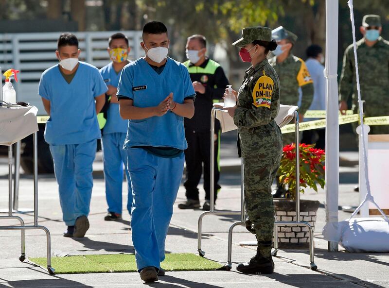 Medical personnel from different institutions arrive to be vaccinated with the Pfizer/BioNTech vaccine against the COVID-19 novel coronavirus, at the Military Field Number 1A in Mexico City. Mexico will first apply the vaccine to all health personnel and the elderly as part of their mass immunization program. AFP