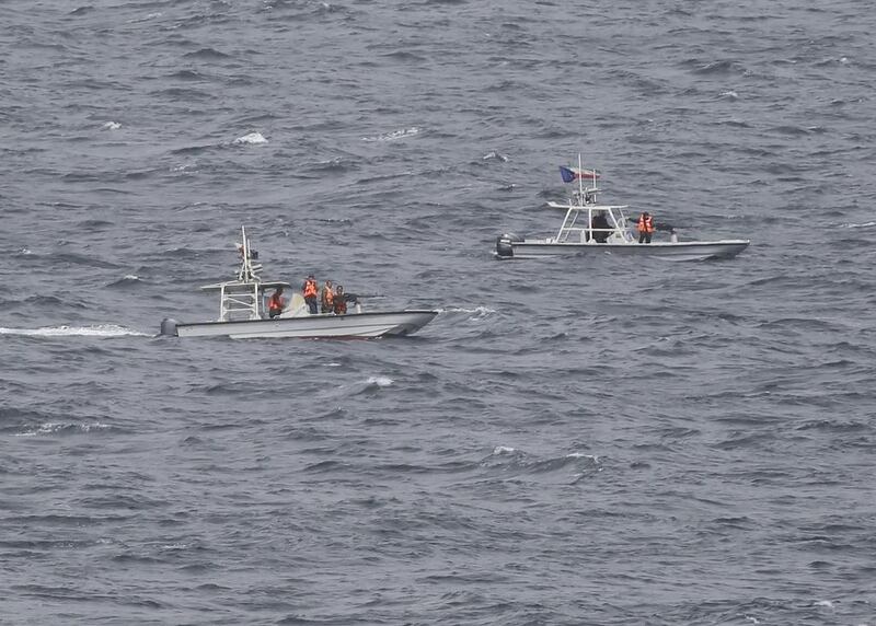 Members of Iran's Revolutionary Guard watch the USS George HW Bush from their armed vessels as the aircraft carrier travels through the Strait of Hormuz on March 21, 2017. Jon Gambrell / AP Photo