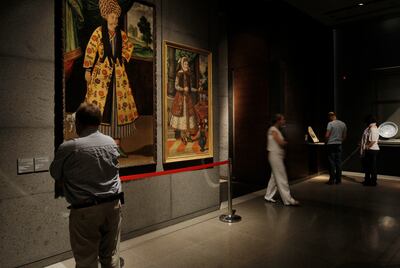 DOHA, QATAR - February 18, 2009: A visitor looks at 17th century oil paintings from Iran while other visitors tour the Museum of Islamic Art on the corniche of Doha, Qatar  (Ryan Carter / The National)

*** For Travel story by Mo Gannon 
 *** Local Caption ***  RC029-TravelDoha.jpgRC029-TravelDoha.jpg