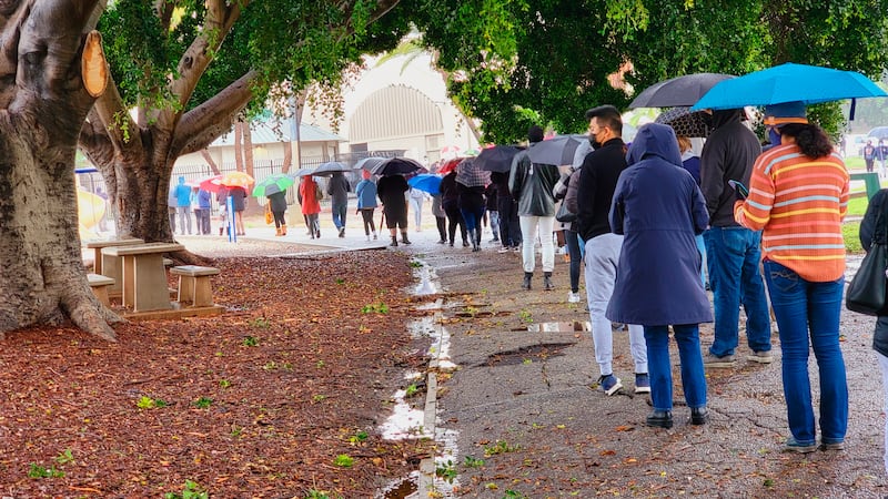 People stand in line under the rain for a free COVID-19 test outside the Lincoln Park Recreation Center in Los Angeles on Thursday, Dec.  30, 2021.  More than a year after the vaccine was rolled out, new cases of COVID-19 in the U. S.  have soared to their highest level on record at over 265,000 per day on average, a surge driven largely by the highly contagious omicron variant.  (AP Photo / Damian Dovarganes)