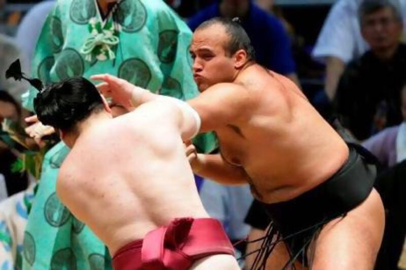 Egyptian sumo ‘Osunaarashi’, right, whose real name is Abdelrahman Ahmed Shalan, defeats Oniarashi during the Nagoya tournament. He is the sport’s first African-Arab sumo.