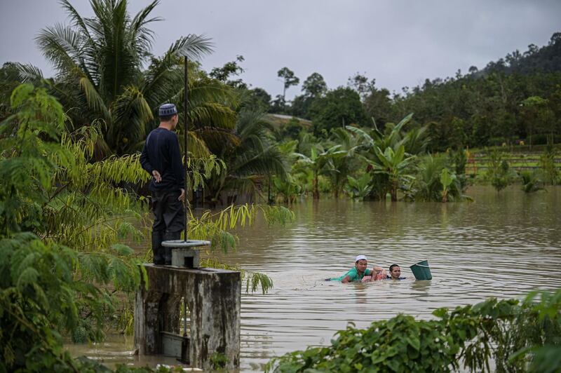 Residents swim in floodwaters in Lanchang in Malaysia's Pahang state. AFP