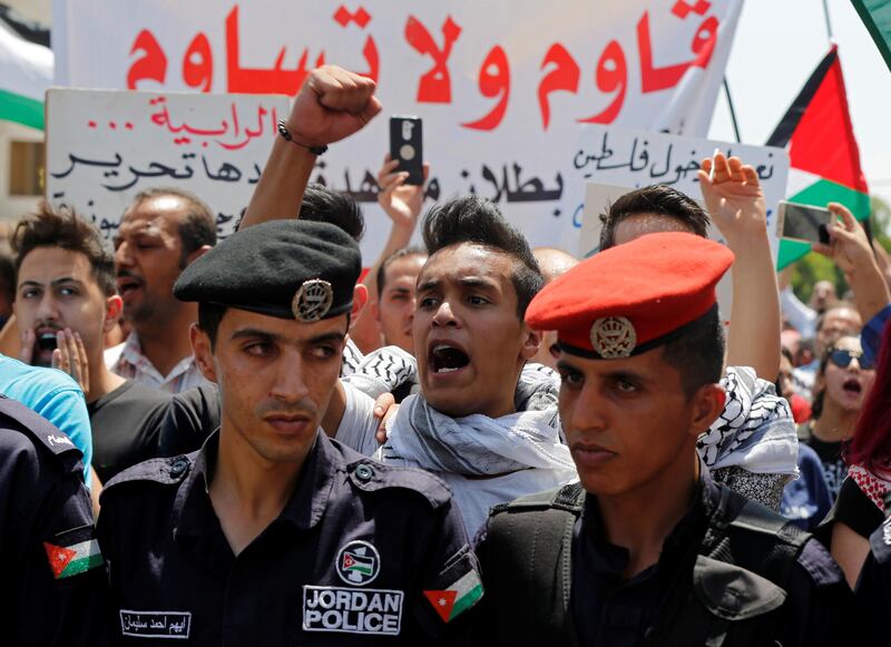 Protesters chant slogans during a demonstration near the Israeli embassy in Amman, Jordan, on July 28, 2017. The banner reads, 'Resist don't submit'. Muhammad Hamed / Reuters