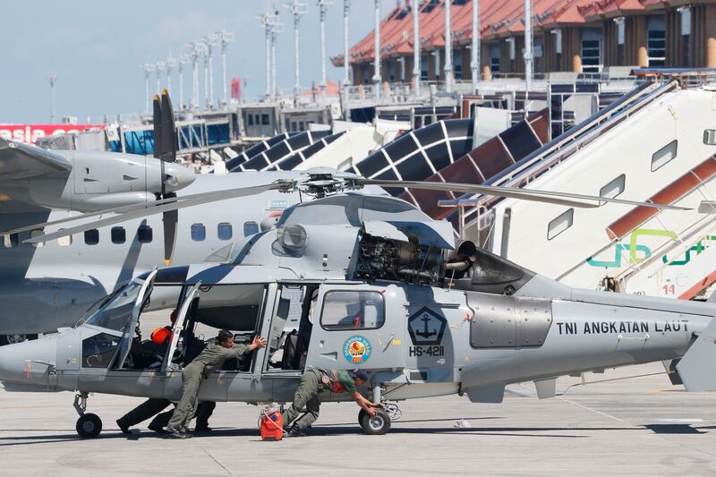 Officers prepare a helicopter before taking part in the search operation for the missing Indonesian Navy submarine KRI Nanggala. EPA