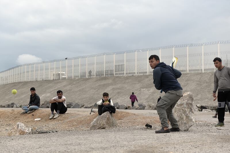 Migrants from Afghanistan play cricket on a makeshift wicket in May 2016