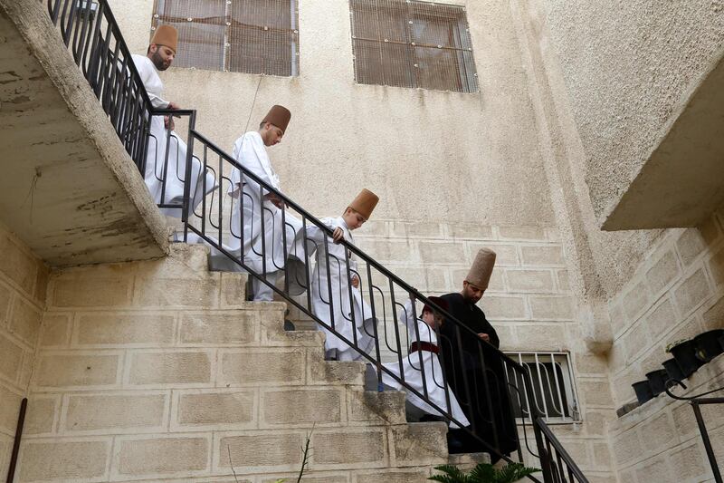 Members of the Al Kharrat family descend a staircase at their home. AFP