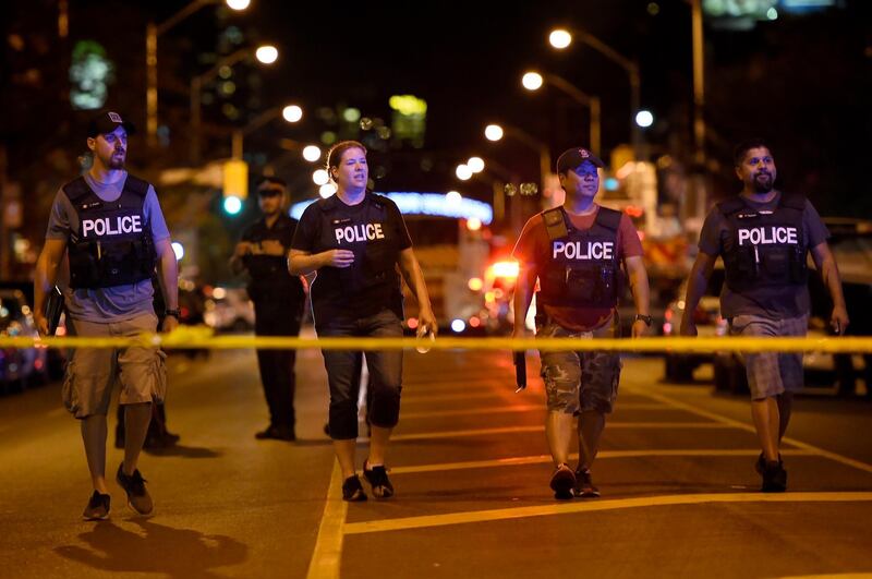 Plainclothes police officers work the scene of shooting in Toronto. AP Photo