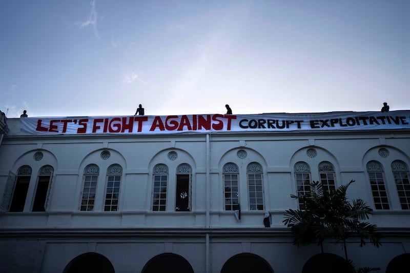 Protesters erect a banner on the presidential palace three days after it was stormed by anti-government demonstrators in Colombo. AP