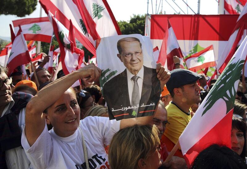 A Lebanese woman holds a picture of Lebanon's newly elected president, Michel Aoun, at the presidential palace in Baabda. Bilal Hussein / AP Photo