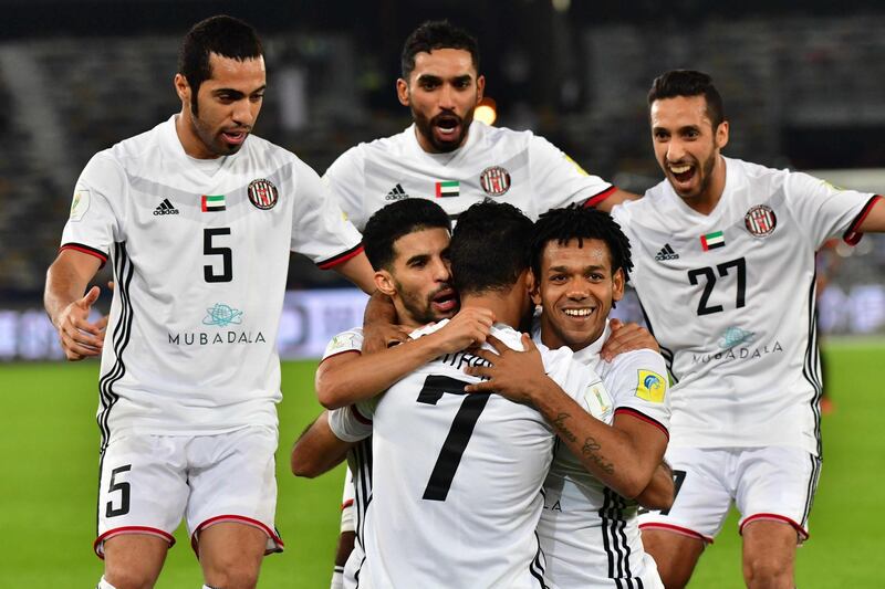 Al-Jazira's Emirati forward Ali Mabkhout (C, front) embraces his teammates Moroccan Mbark Boussoufa (C-L, behind) and Brazillian Romarinho (C-R, behind), as they celebrate after him scoring a goal against Urawa Reds during their FIFA Club World Cup quarter-final match at Zayed Sports City Stadium in the Emirati capital Abu Dhabi on December 9, 2017. / AFP PHOTO / GIUSEPPE CACACE
