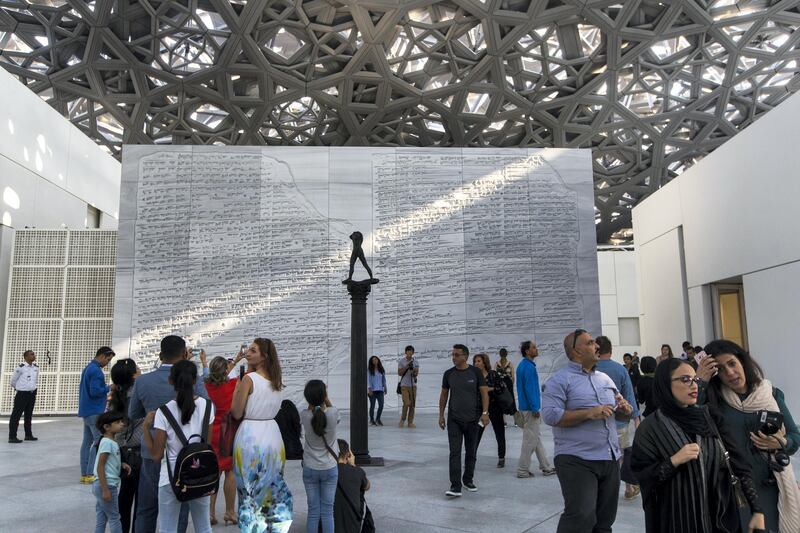 Abu Dhabi, United Arab Emirates, November 11, 2017:    Visitors walk past the Walking Man, On a Column sculpture by artist Augusta Rodin on the opening day at the Louvre Abu Dhabi on Saadiyat Island in Abu Dhabi on November 11, 2017. Christopher Pike / The National

Reporter: James Langton, John Dennehy
Section: News