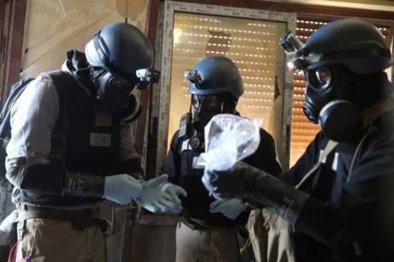 A U.N. chemical weapons expert, wearing a gas mask, holds a plastic bag containing samples from one of the sites of an alleged chemical weapons attack in the Ain Tarma neighbourhood of Damascus August 29, 2013. A team of U.N. experts left their Damascus hotel for a third day of on-site investigations into apparent chemical weapons attacks on the outskirts of the capital. Activists and doctors in rebel-held areas said the six-car U.N. convoy was scheduled to visit the scene of strikes in the eastern Ghouta suburbs. REUTERS/Mohamed Abdullah (SYRIA - Tags: POLITICS CIVIL UNREST CONFLICT TPX IMAGES OF THE DAY) *** Local Caption ***  SYR12_SYRIA-CRISIS-_0829_11.JPG