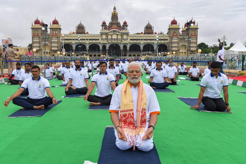 India's Prime Minister Narendra Modi performs yoga with others to celebrate the International Day of Yoga in front of the Mysore Palace in Mysore on June 21, 2022.  (Photo by Manjunath Kiran  /  AFP)