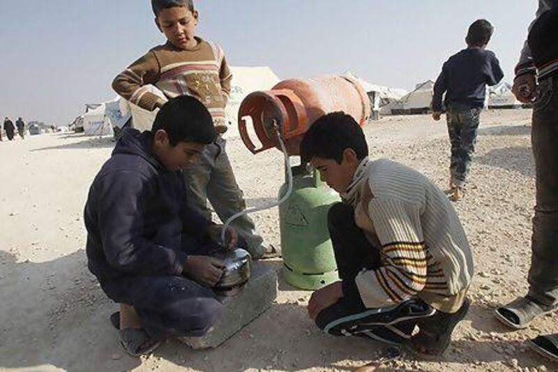 Syrian refugee boys fill cooking gas cylinders at the Al Zaatari refugee camp in the Jordanian city of Mafraq, near the Syrian border, where it is now almost impossible to obtain gas.