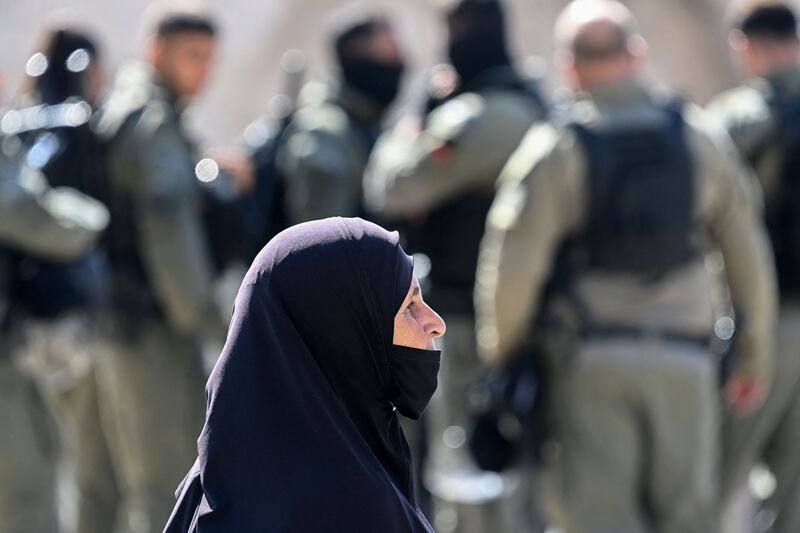 A Palestinian woman waits to cross into Jerusalem's Old City through Damascus Gate next to Israeli soldiers. AFP