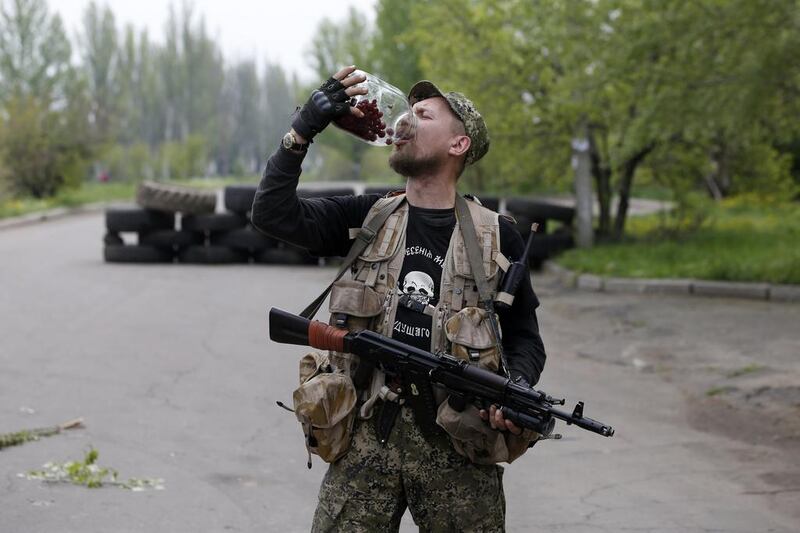 A pro-Russian rebel eats cherries from a bottle at a checkpoint near a Ukrainian airbase in Kramatorsk, eastern. Marko Djurica / Reuters / May 2, 2014