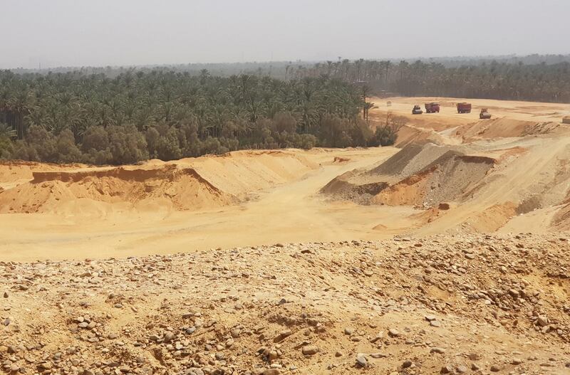 Trucks move past construction as a new superhighway emerges from palm groves near the ancient capital of Memphis towards the desert in Giza, Egypt September 2, 2020. Picture taken September 2, 2020. REUTERS/Staff