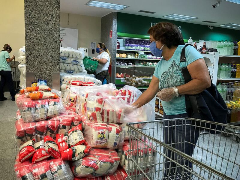 epa08385650 People buy items in a supermarket in Caracas, Venezuela, 26 April 2020. The Venezuelan Government has recently announced a price control to three companies producing food. Among those companies is Alimentos Polar, one of the biggest companies in the country.  EPA/Rayner PeÃ±a