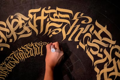 This photo taken on June 22, 2019 shows artist Taipan Lucero doing calligraphy using the indigenous script known as Baybayin, used before Spanish colonisation in 1521, at an event in Manila. From tattoos, shirts, and artworks to a computer font and mobile apps, Baybayin found a rebirth among millennials and professionals learning its 17 characters beyond the marginal mention in history class. 
 - TO GO WITH AFP STORY: Philippines-culture-language, FEATURE by Ayee MACARAIG
 / AFP / Noel CELIS / TO GO WITH AFP STORY: Philippines-culture-language, FEATURE by Ayee MACARAIG
