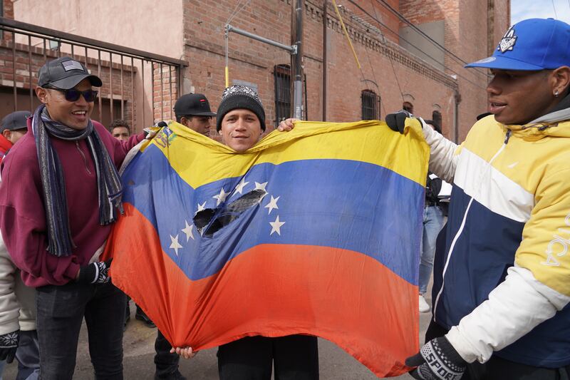 Migrants hold up a Venezuelan flag during a march in El Paso. Willy Lowry / The National