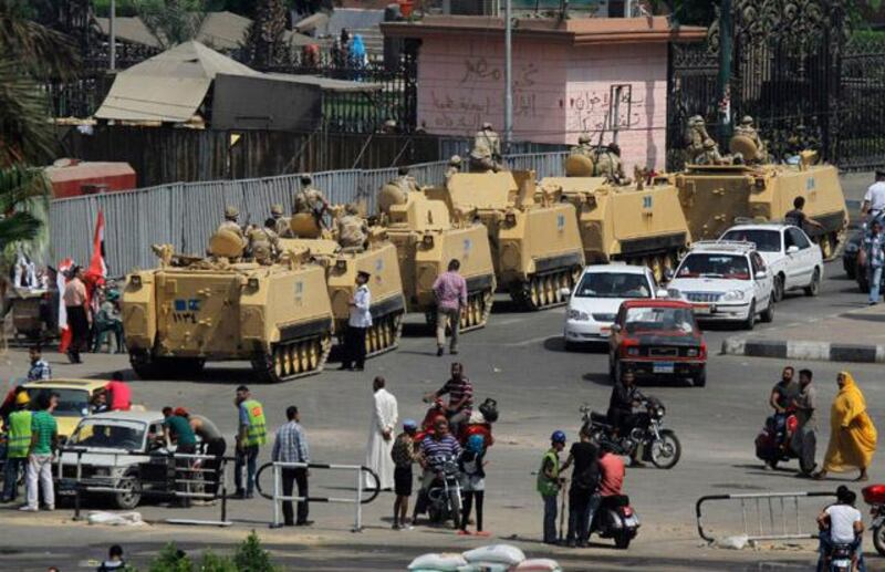 Egyptian soldiers on armored personnel carriers stand guard on a street to Tahrir Square in Cairo, Egypt, Monday, July 8, 2013. Tens of people were killed Monday in clashes outside a military building in Cairo where supporters of the former president were holding a sit-in, an Egyptian health ministry official said. (AP Photo/Amr Nabil)