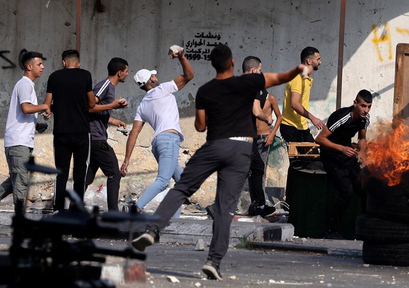 Protesters hurl rocks at Israeli security forces' vehicles. AFP