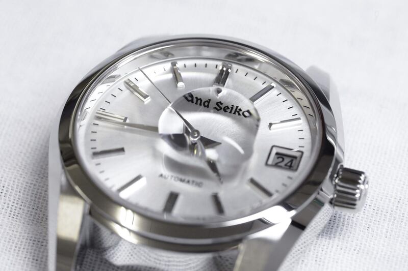 A droplet of water sits on the face of a A Grand Seiko.