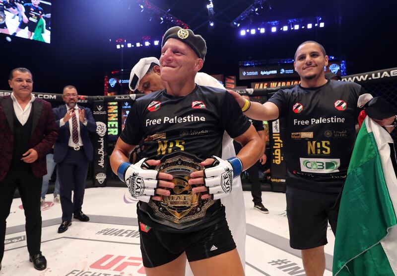 Ali Al Qaisi celebrates with the featherweight belt after beating Jesse Arnett at UAE Warriors 33 at Etihad Arena, Yas Island, Abu Dhabi. All photos Chris Whiteoak / The National