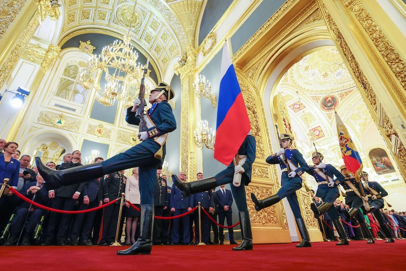Soldiers carry the Russian national flag and the Standard of the President of the Russian Federation into the Kremlin's ornately decorated Andreyevsky Hall. AFP