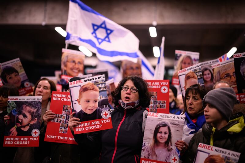 Protesters holding images of children believed to be hostages in Gaza attend a rally outside the Red Cross's London offices. Getty Images