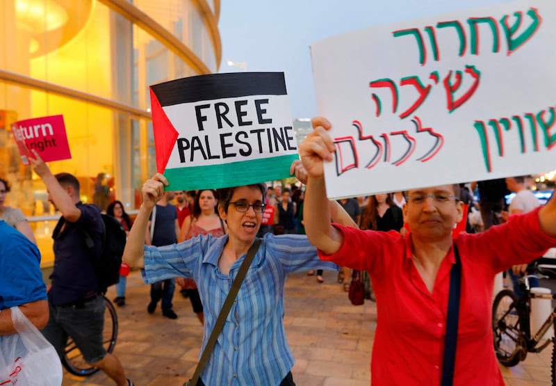 Left wing Israelis hold slogans during a protest against Eurovision in Tel Aviv. AFP