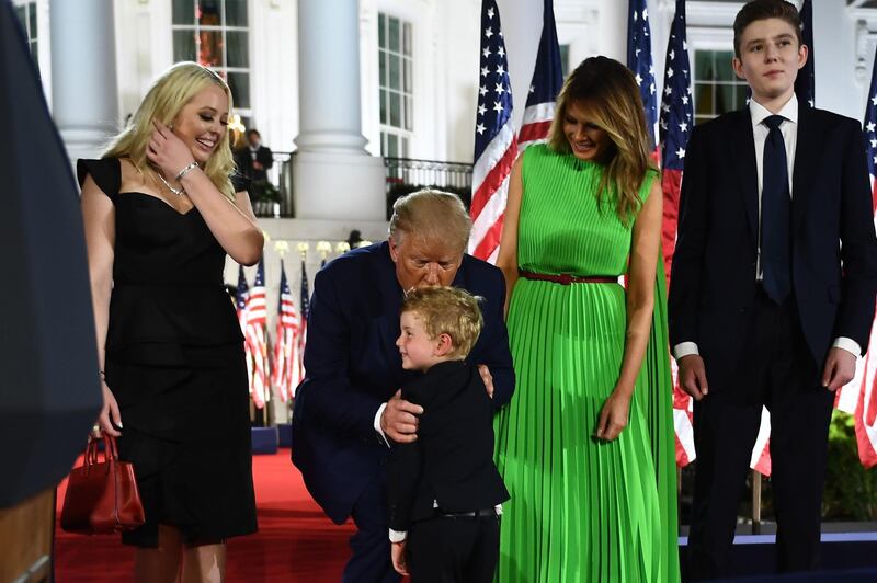 First lady Melania Trump (2nd R), Barron Trump (R) and Tiffany Trump look on as US President Donald Trump  kisses grandson Theodore James Kushner. AFP