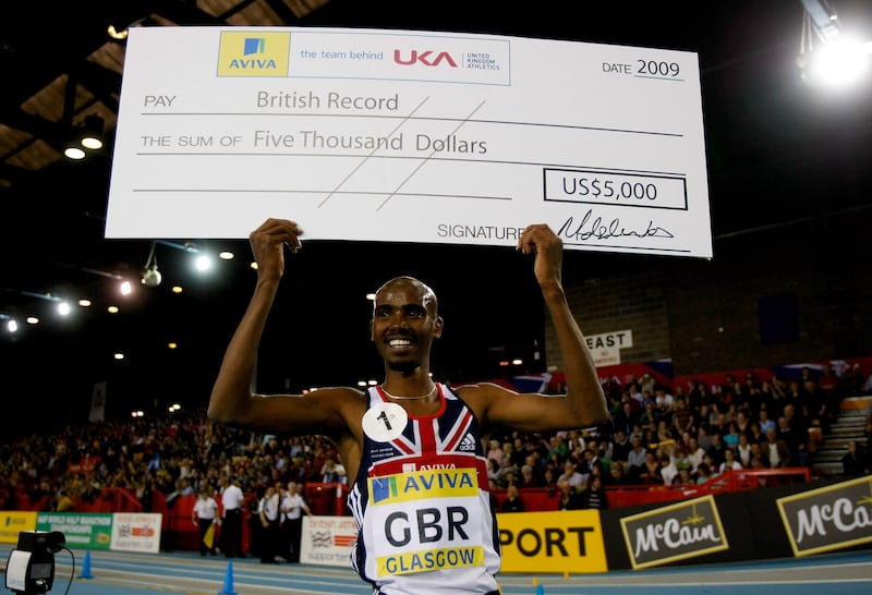 Farah celebrates with a cheque after winning a 3,000m race in Glasgow, Scotland, in 2009. Getty Images