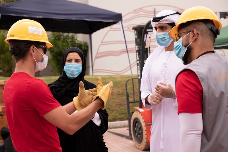 Sarah Al Amiri, Minister of State for Advanced Technology and chairperson of the UAE Space Agency, and mission director Omran Sharaf, third left, discuss with engineers shipping the Hope probe to Japan. Photo: Mohammed bin Rashid Space Centre