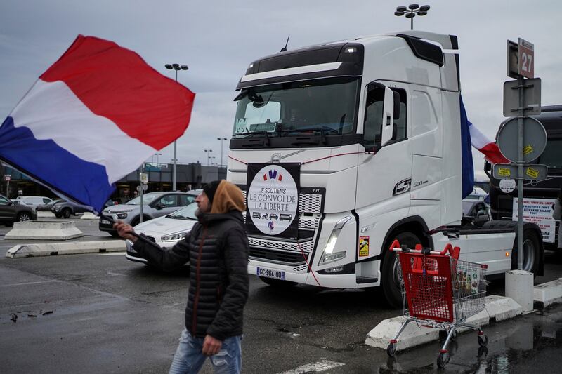 A protester waves a French flag next to a lorry taking part in a convoy in Lyon, central France. AP Photo