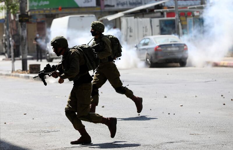 epa08530952 Israeli soldiers take up position during clashes with Palestinian protesters in the West Bank City of Hebron, 06 July 2020. Palestinians are protesting against an expected Israeli move to annex parts of the West Bank and Jordan Valley occupied by Israel since the 1967 Middle East war. The annexation move is supported by the Israeli-Palestinian Peace Plan of US President Donald Trump, unveiled in January 2020, but widely rejected in the region.  EPA/ABED AL HASHLAMOUN