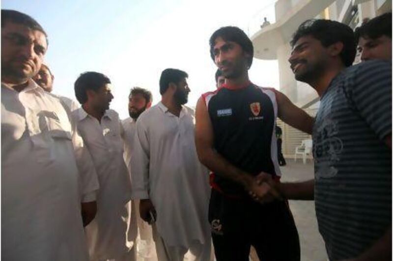 Abdul Haq, centre right, a lorry driver who impressed the Pakistani coaches, is greeted by fans at Sheikh Zayed Cricket Stadium.