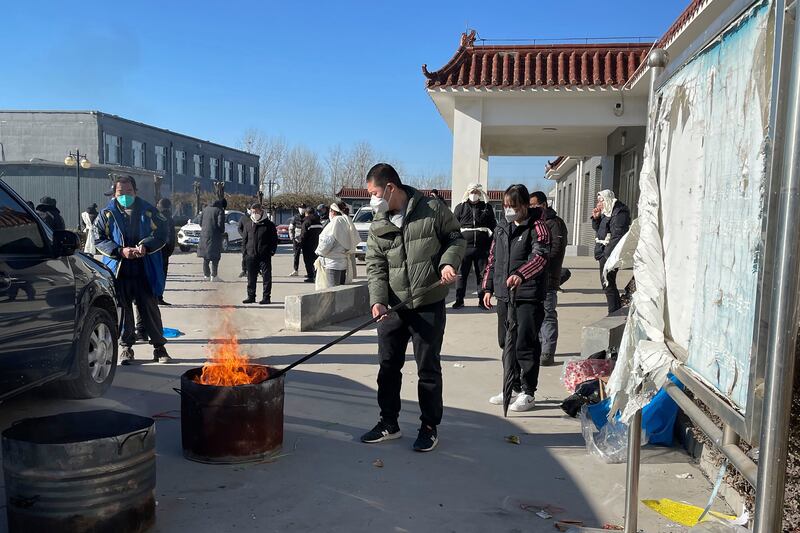 Relatives burn paper offerings for a relative who died, at the Gaobeidian Funeral Home in northern China's Hebei province. AP
