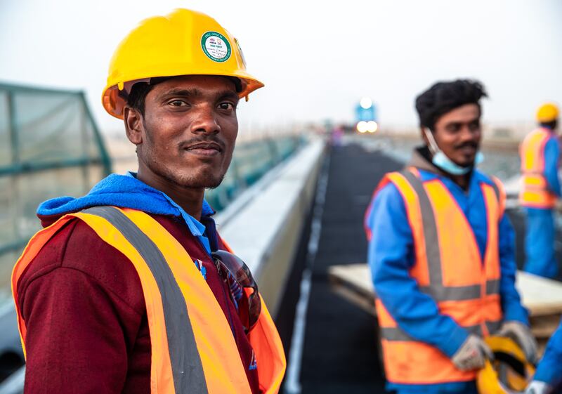 Etihad Rail workers on a railroad overpass along the E77 and E611 highway junction in Dubai.