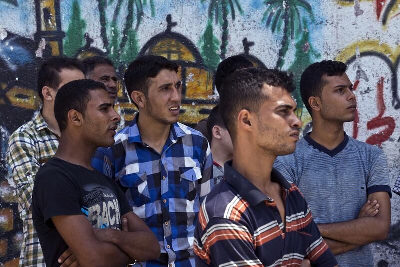 Palestinian men assessing the damage left from a collapsed building, that was targeted by Israeli airstrikes overnight. Roberto Schmidt/AFP Photo