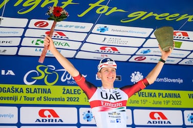 Slovenia’s cyclist Tadej Pogacar (L) of the UAE Team Emirates celebrates on the podium after winning the 5th and last stage (155,7 km from Vrhnika to Novo mesto) during the Tour of Slovenia cycling race in Novo Mesto on June 19, 2022.  (Photo by Jure Makovec  /  AFP)