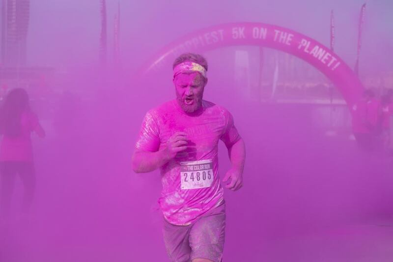 A participants races through plumes of pink powder to finish the 5km run. Clint McLean for The National