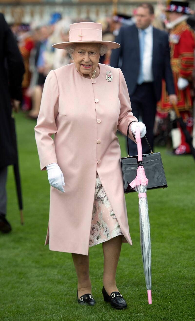 Queen Elizabeth II, wearing light pink, during a garden party at Buckingham Palace on May 16, 2017, in London. Getty Images