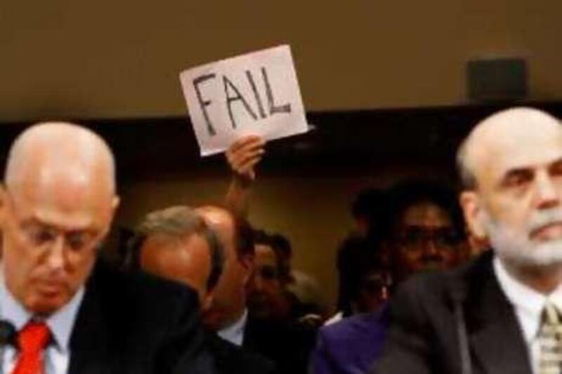 Henry Paulson, left, and the Federal Reserve chairman Ben Bernanke are silently heckled at the Senate banking committee meeting.