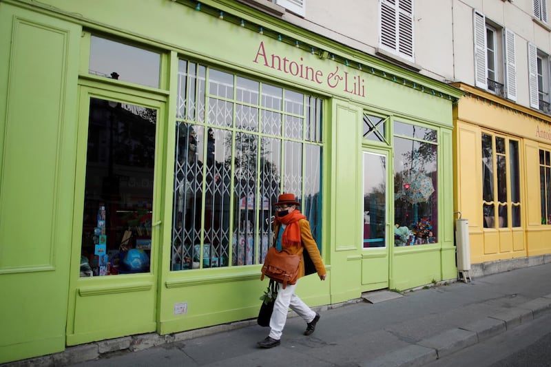A woman walks past a closed shop in Paris, France. Reuters
