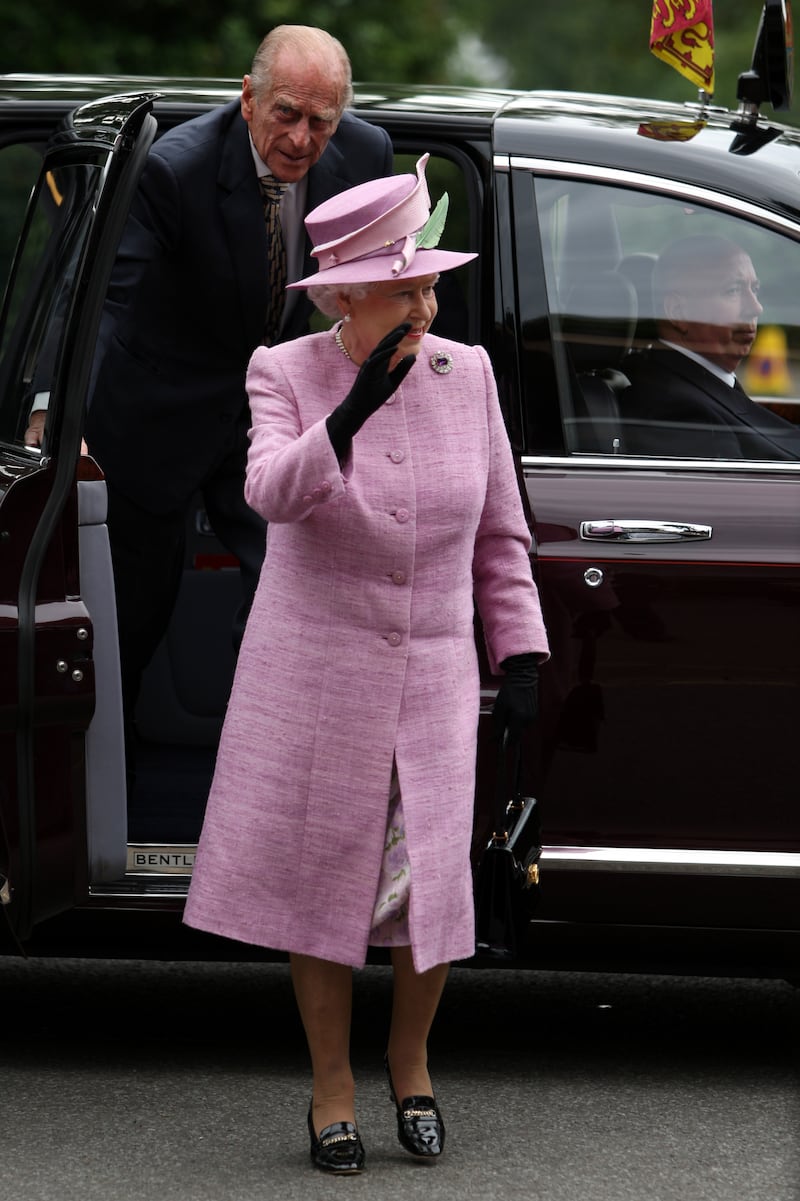 Queen Elizabeth II, wearing pink, and Prince of Philip, Duke of Edinburgh, arrive at the Royal Botanic Garden Edinburgh on July 12, 2010. Getty Images